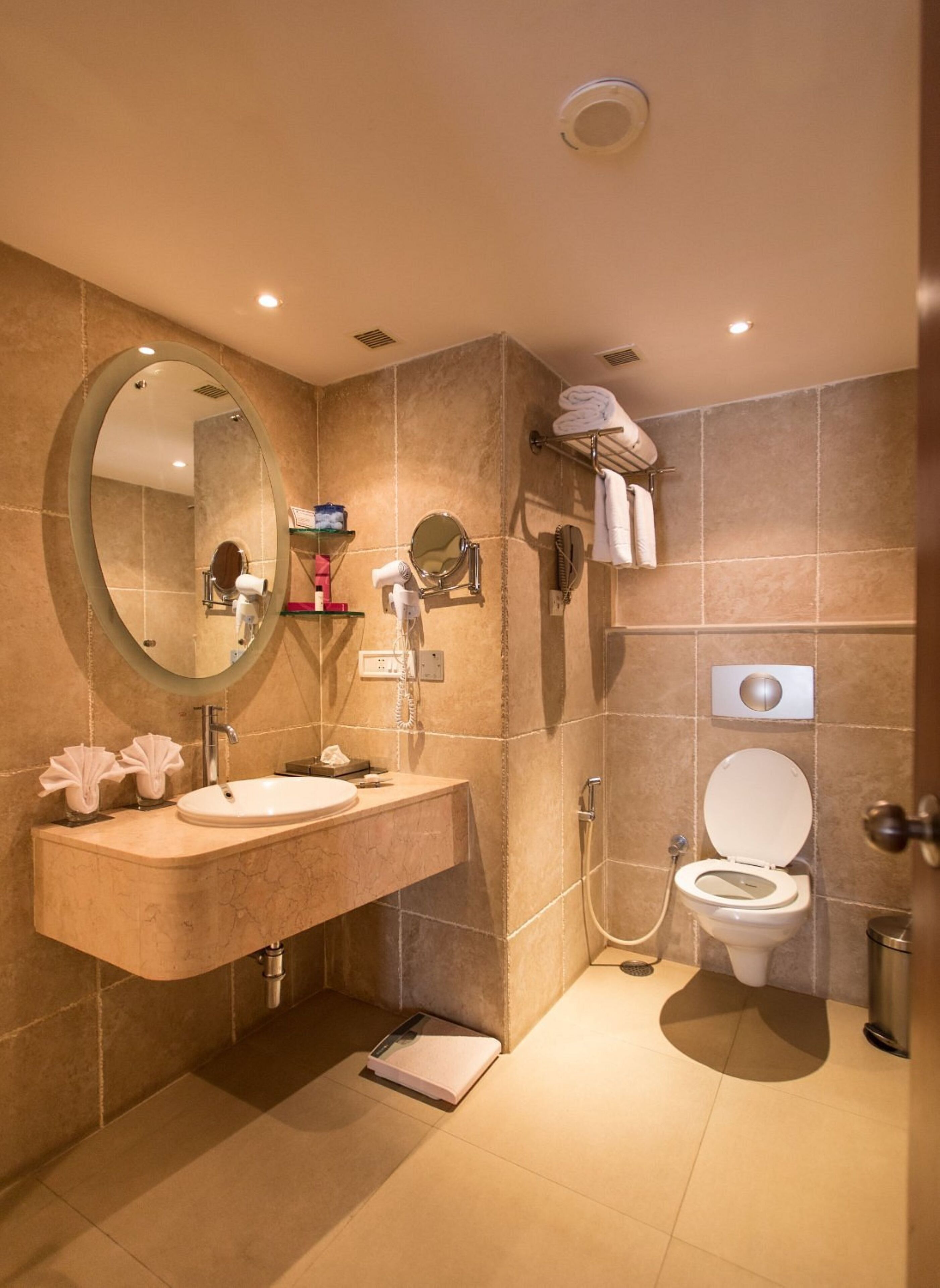 Un baño moderno con tocador, inodoro, ducha y espejo.