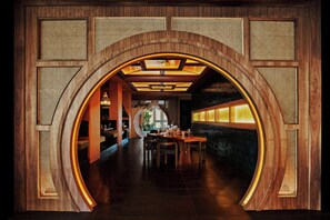 Un interior con un arco de madera, un comedor y vistas a un jardín.