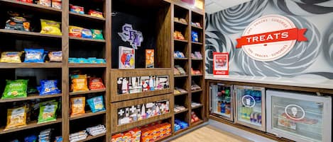 A snack display with various packaged foods and a refrigerated section.