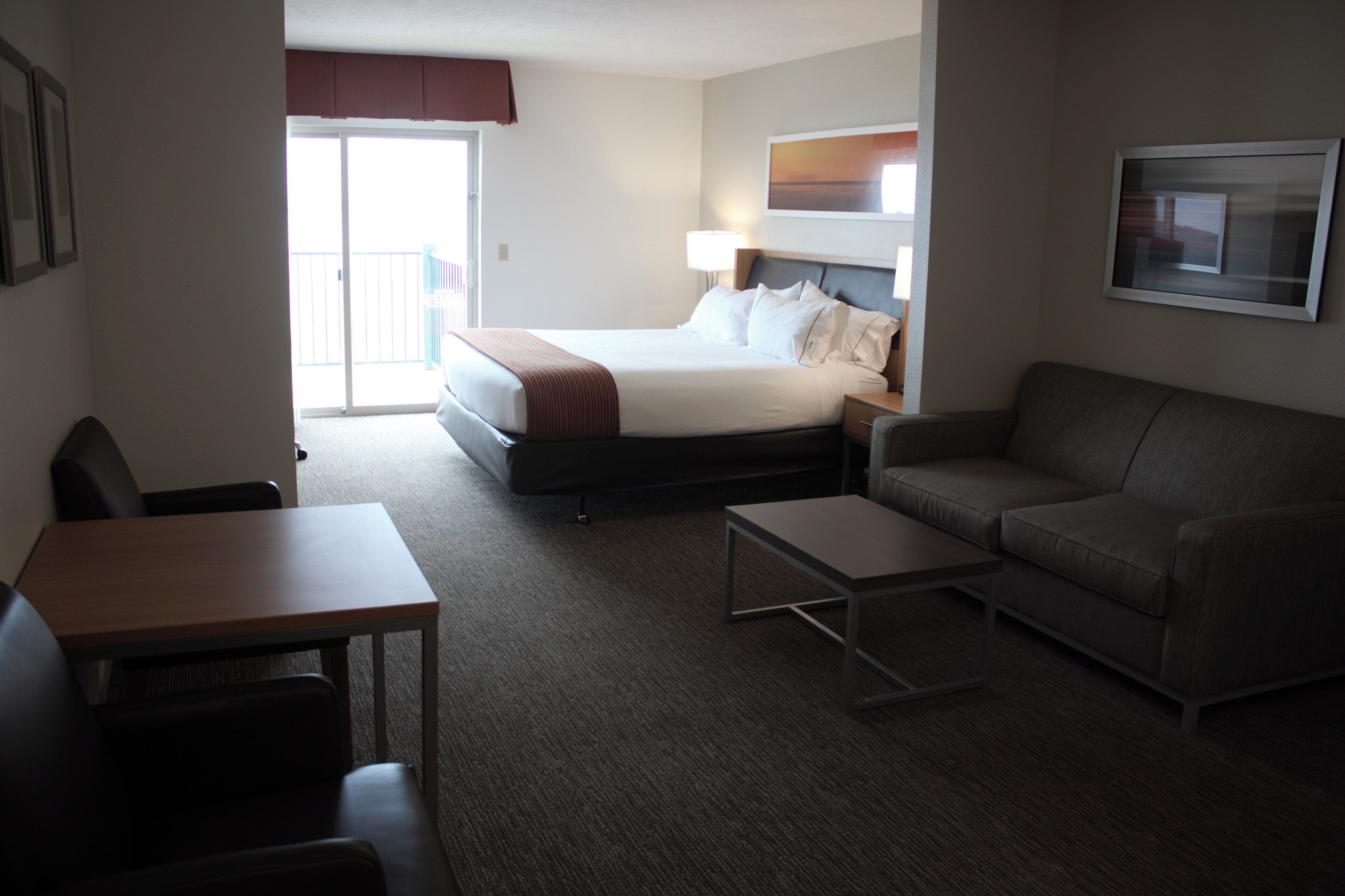 Una habitación de hotel con una cama, un sofá, una mesa y una silla.
