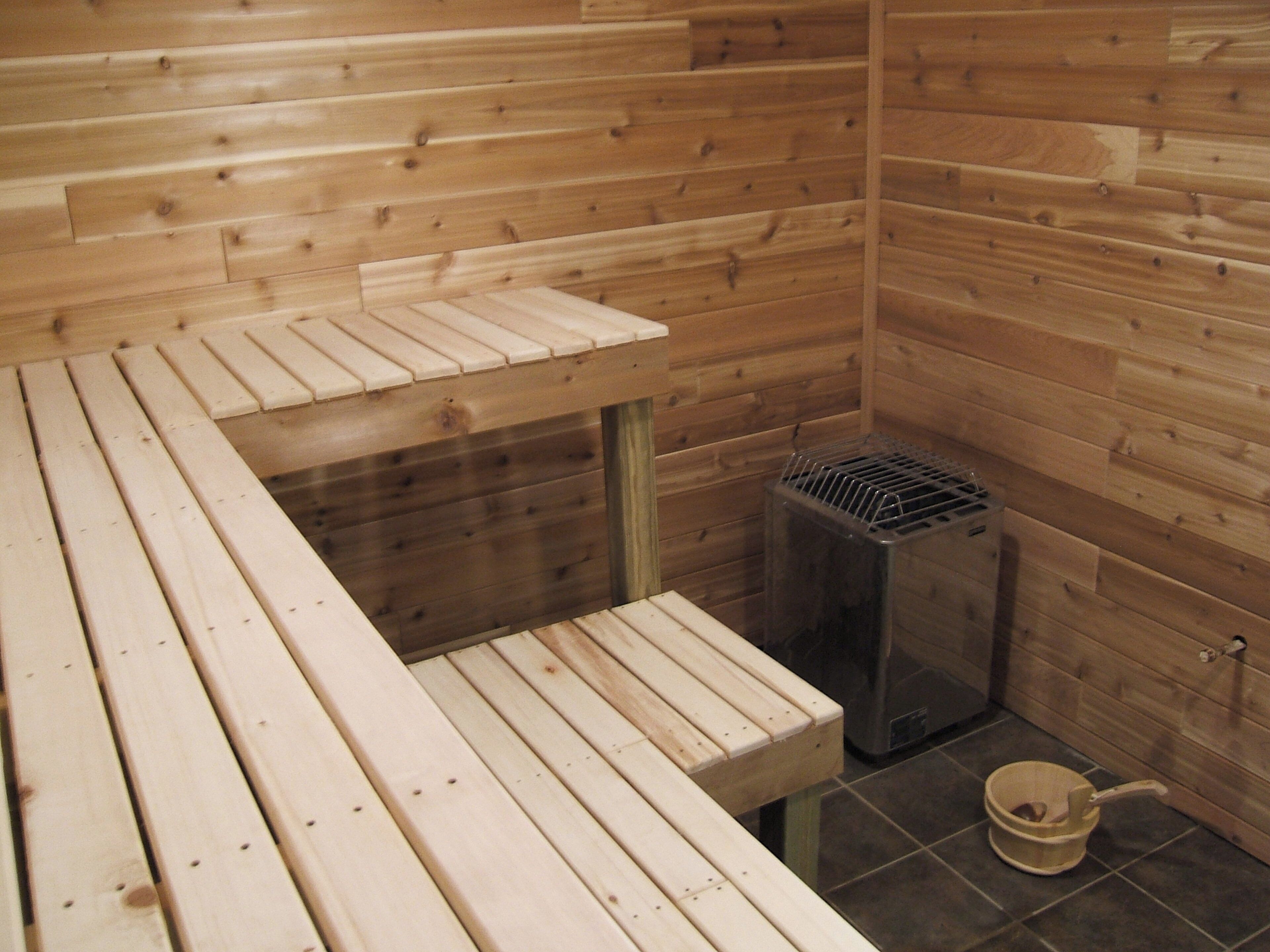 A sauna room with wooden benches and a glass door.