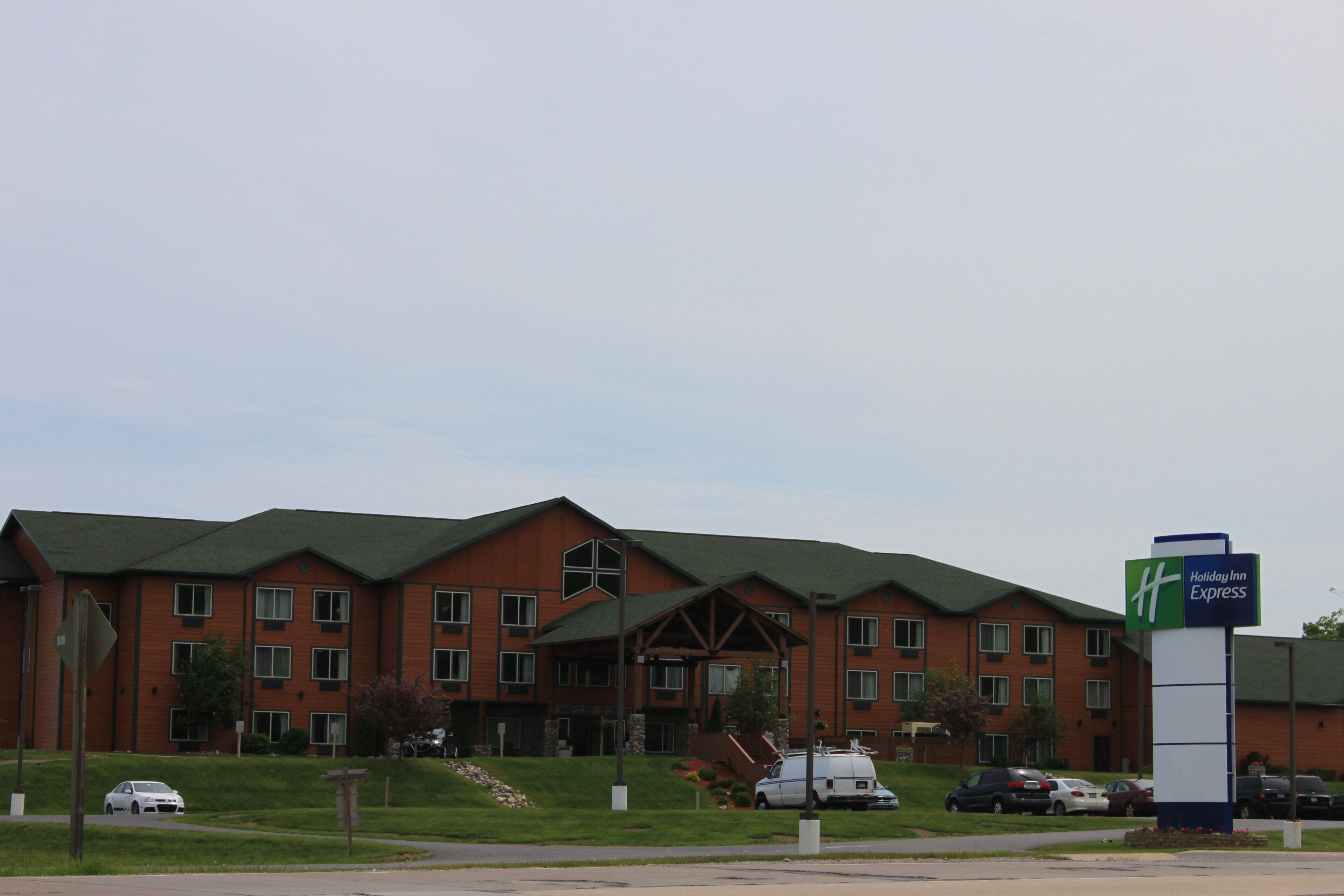 A Holiday Inn Express hotel with a brick facade, multiple windows, and a green roof.