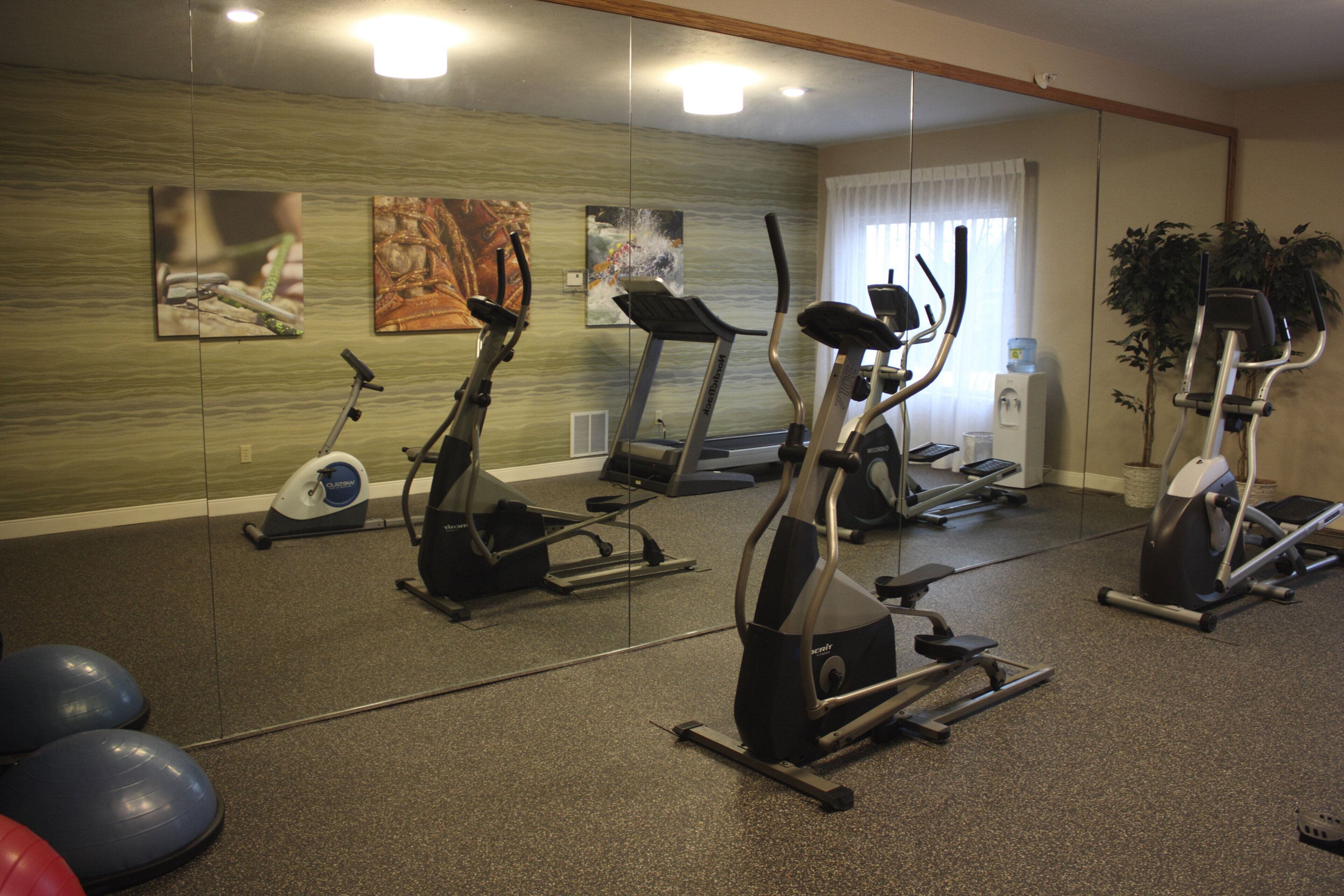 A gym with stationary bikes, treadmills, and exercise balls.