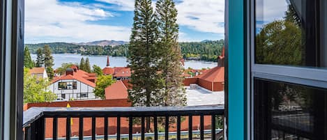 Un balcón con vistas a un pueblo, que incluye edificios y un lago.