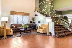 A spacious living area with a sofa, armchairs, and a coffee table. A staircase with a patterned carpet leads to an upper level. - Sleep Inn Columbia Gateway (Jessup)