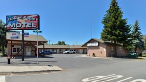 Un motel con un letrero grande, un estacionamiento y un edificio que indica disponibilidad.
