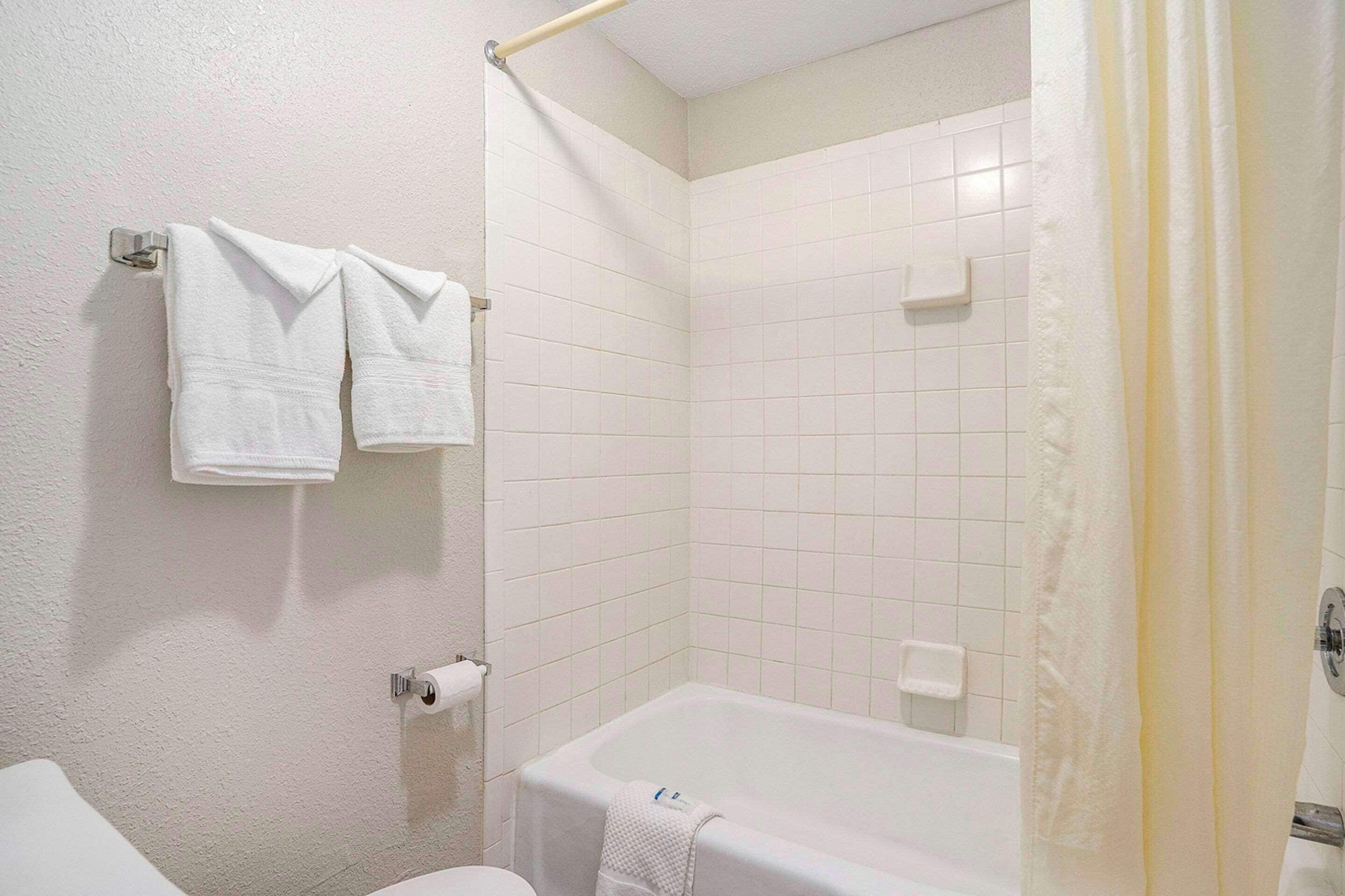 Une salle de bain équipée d’une baignoire, de toilettes et d’un porte-serviettes avec deux serviettes.