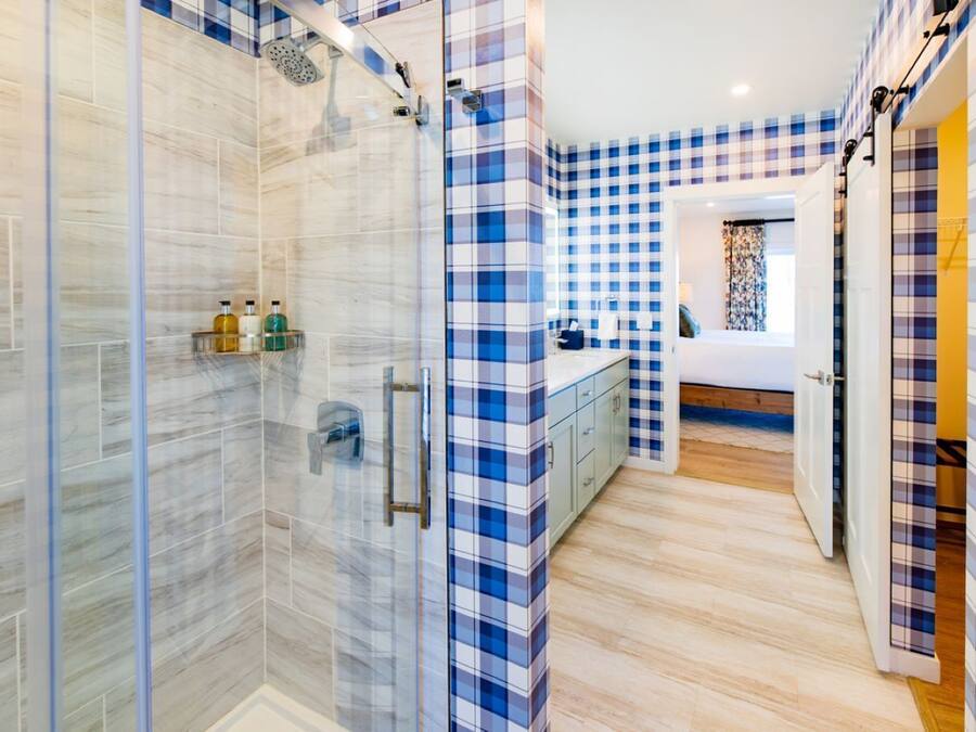 Une salle de bain moderne dotée d’une cabine de douche en verre, d’une douche à l’italienne et de toilettes apparentes.