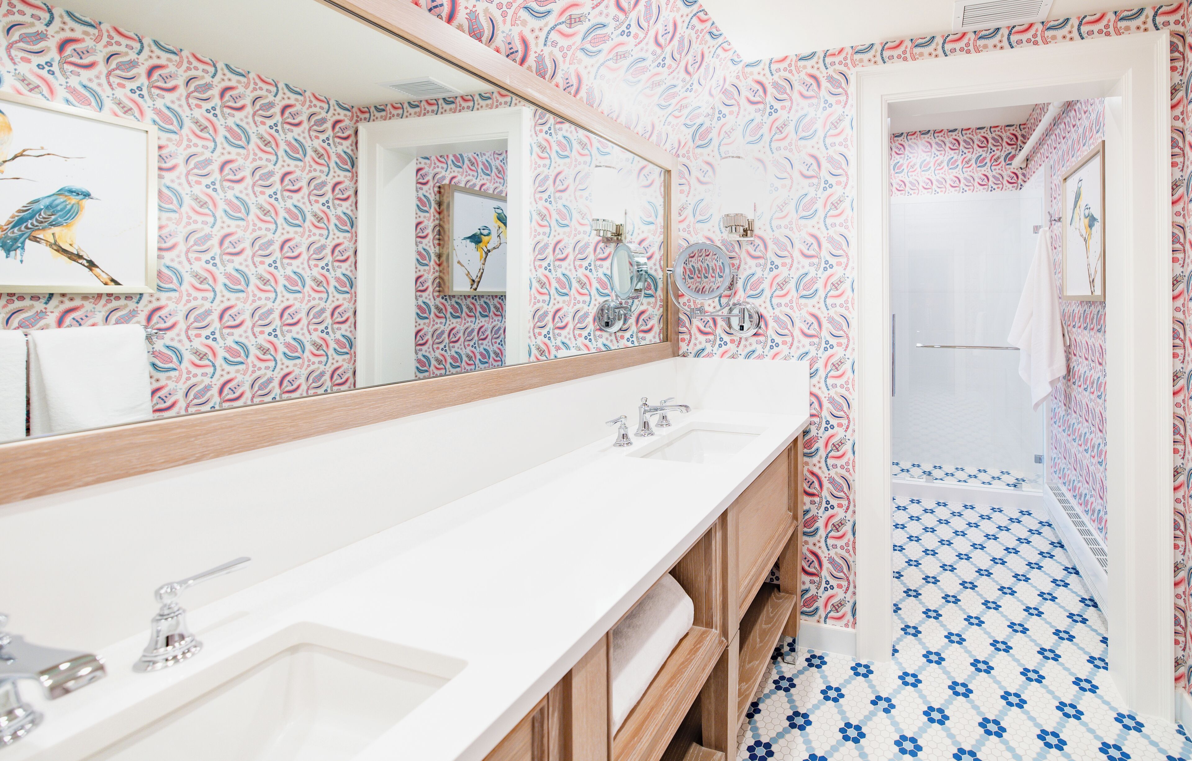 A bathroom with a white sink, a mirror, and a shower area.