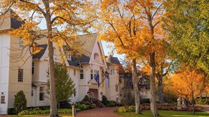 A large, white building with a symmetrical facade, multiple windows, and a central entrance with steps. - The Inn At Stonecliffe (Mackinac Island)