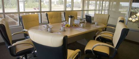 A conference room with a large table, chairs, and a laptop.