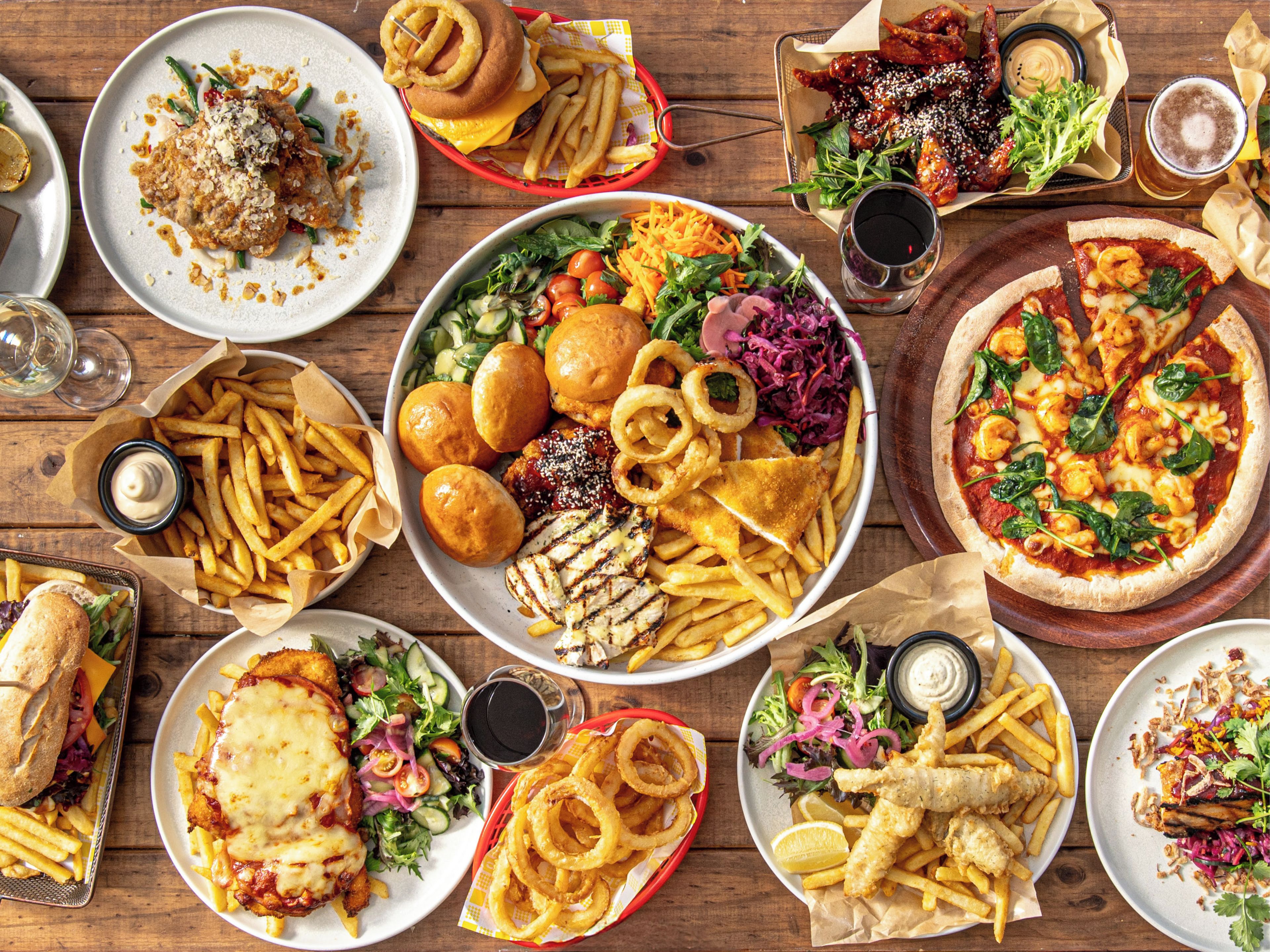 A variety of dishes including pizza, salads, and seafood, suggesting a diverse menu.