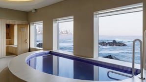 Una piscina interior moderna con vistas al océano.