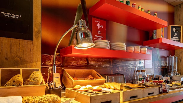 A breakfast buffet with various breads and pastries, a coffee machine, and a sign indicating the next batch is due. - ibis Paris Boulogne Billancourt (Boulogne-Billancourt)