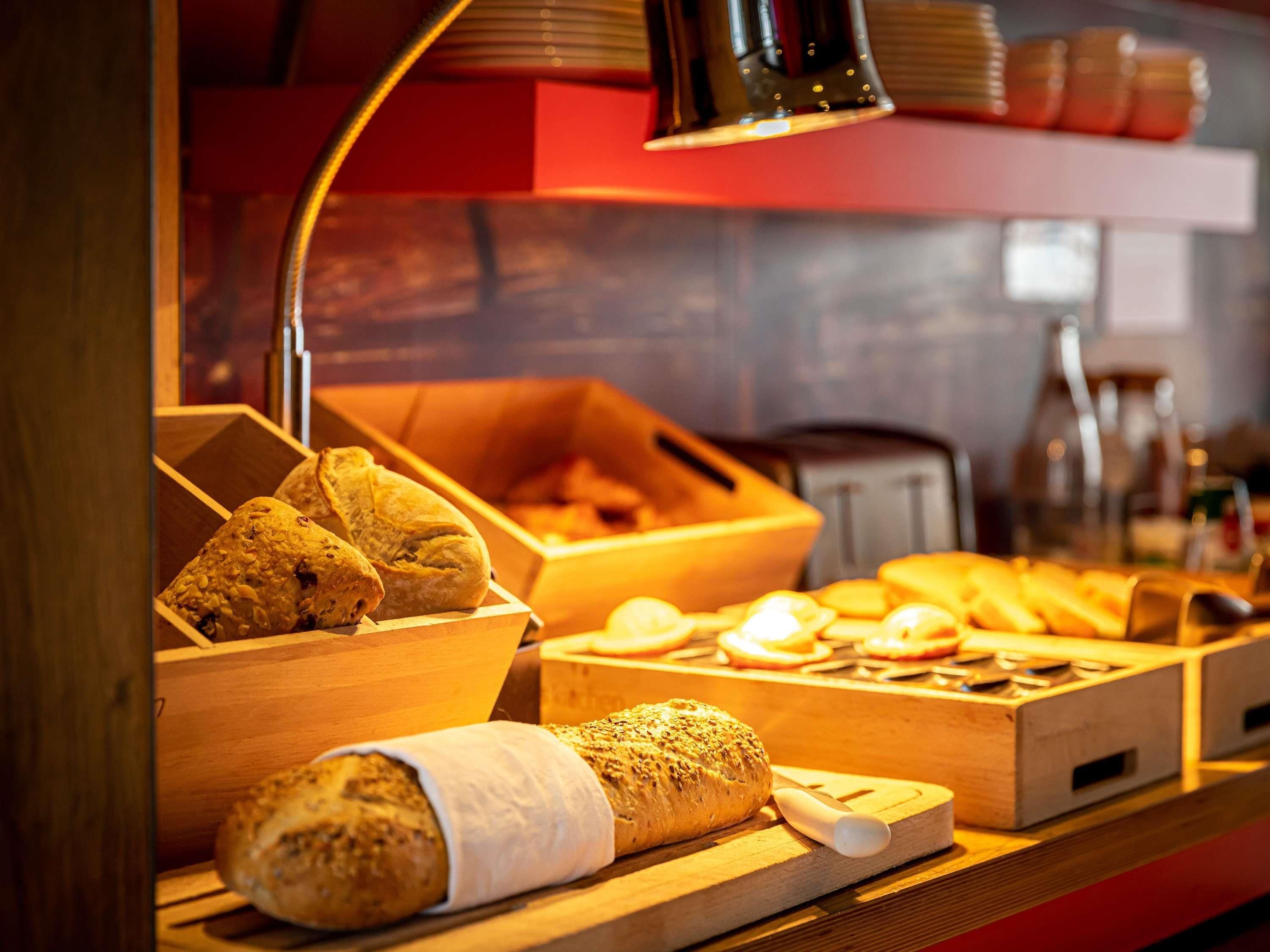 A bakery display with various baked goods and a bread slicer.