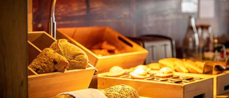 A bakery display with various baked goods and a bread slicer.