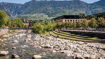 Un río con rocas, un puente y un edificio de diseño moderno.