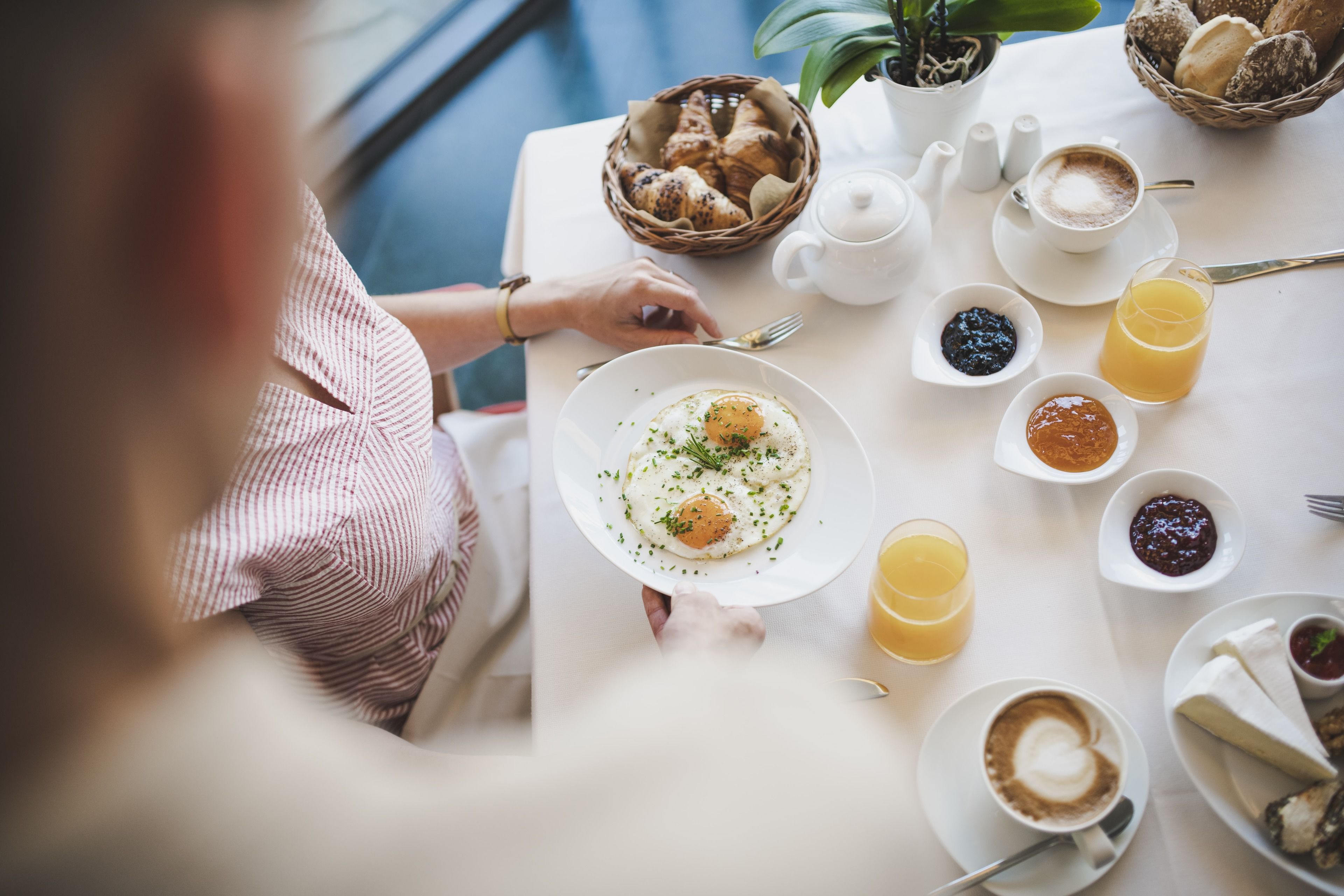 A breakfast table with croissants, coffee, and orange juice.