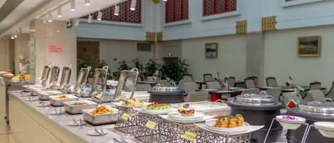 A buffet setup with various food items and utensils.
