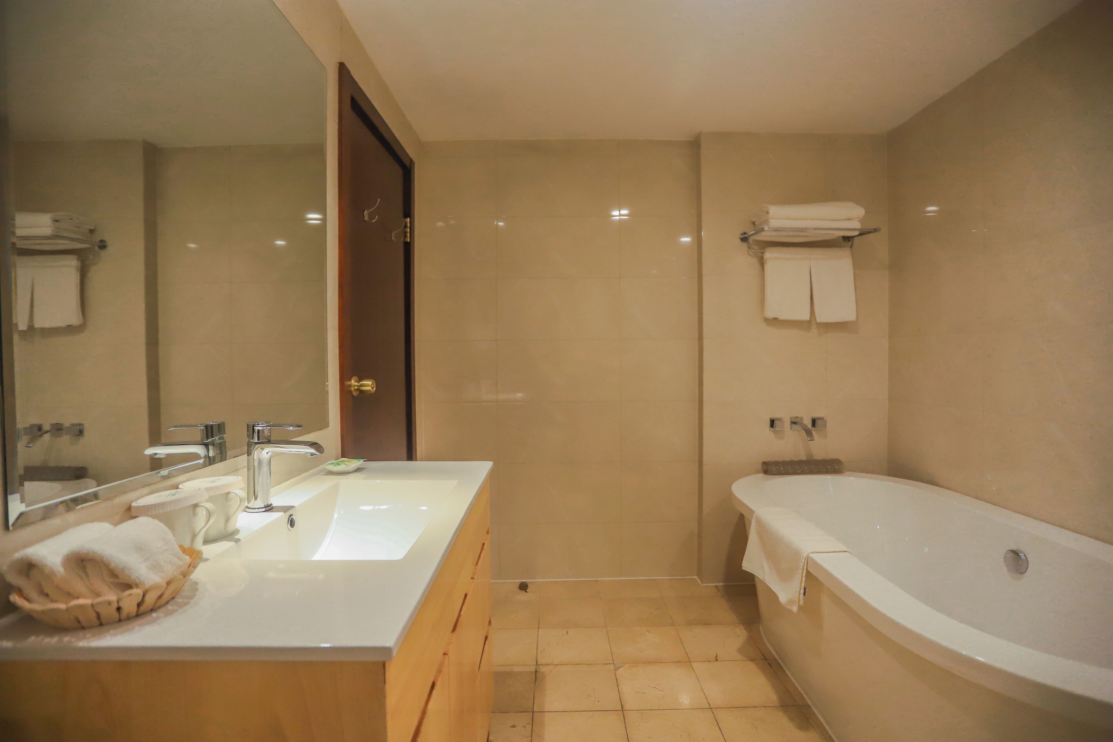 A modern bathroom with a large bathtub, a sink with a mirror, and a shower area.
