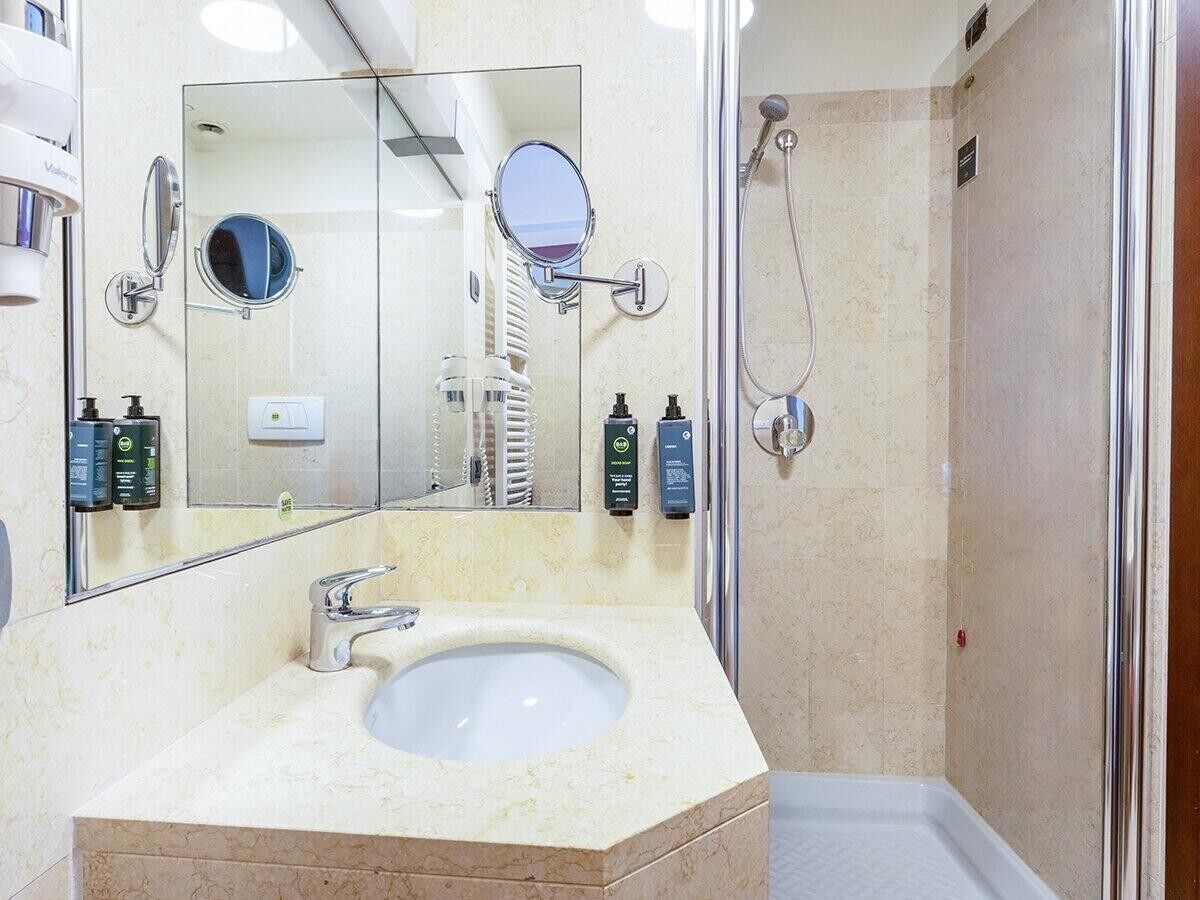 Ein Badezimmer mit Waschbecken, Spiegel und Dusche.