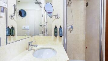 Ein Badezimmer mit Waschbecken, Spiegel und Dusche.