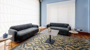 Una sala de estar moderna con dos sofás, una mesa de centro y una alfombra estampada.