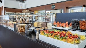 A buffet area with various food options including fruits, nuts, and pastries. - B&B HOTEL Imperia Rossini al Teatro (Imperia)