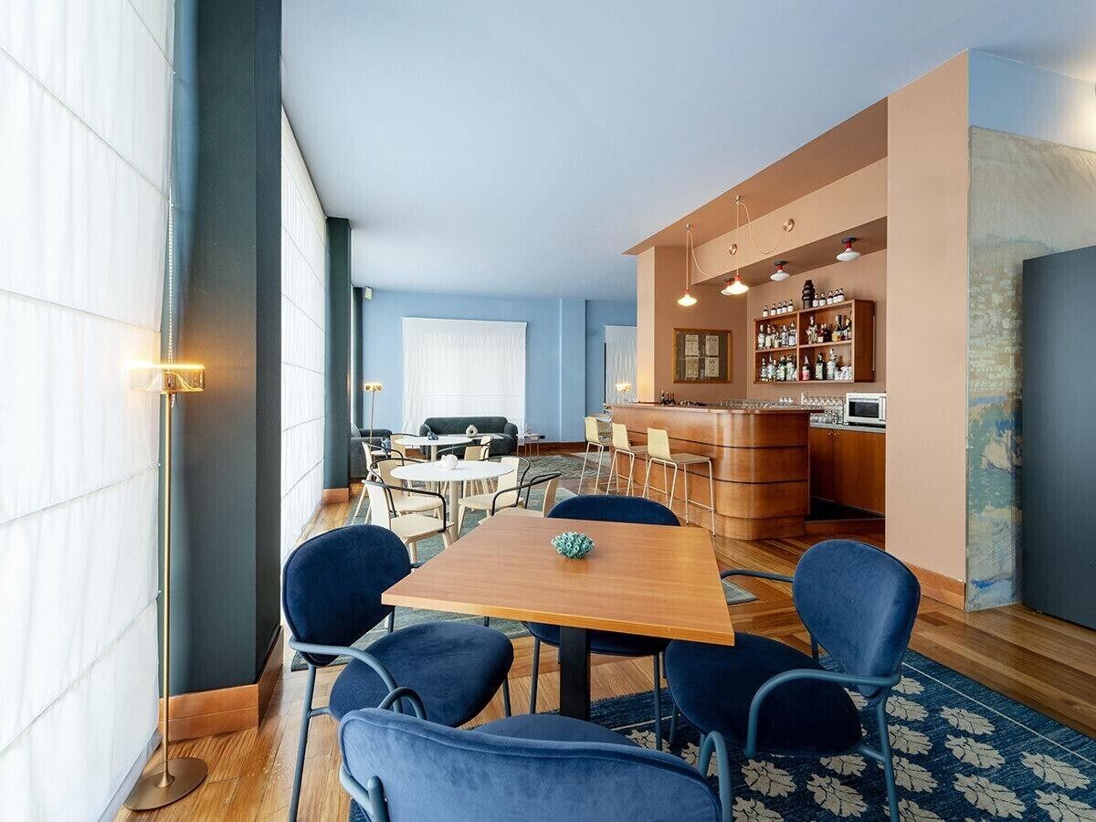 Ett modernt hotellrum med en matplats, ett kök och en bar.