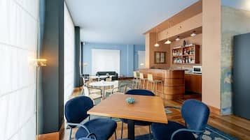 Ett modernt hotellrum med en matplats, ett kök och en bar.