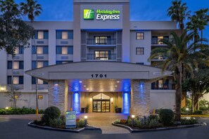 Un bâtiment de l’hôtel Holiday Inn Express, avec une entrée bien visible, une enseigne au-dessus du hall d’entrée et un panneau indiquant le numéro 1701.