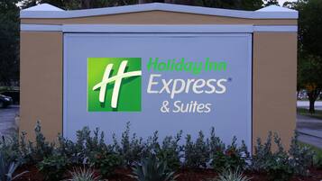 A Holiday Inn Express & Suites sign with a green logo and white lettering.