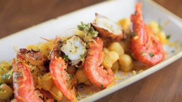 Un plato con camarones, vieiras y garbanzos.