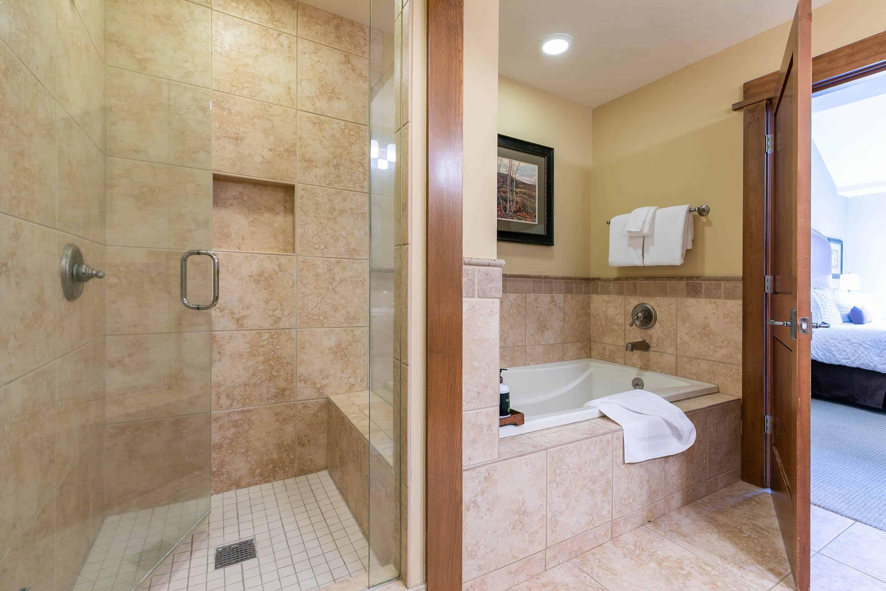 Ein modernes Badezimmer mit einer Glasdusche, einer freistehenden Badewanne und Fliesenboden.