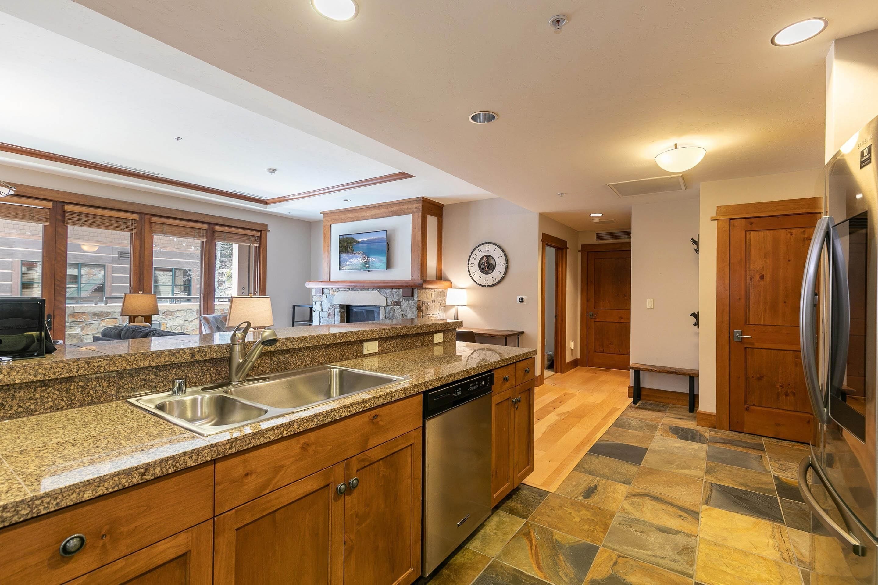 A modern kitchen with granite countertops, stainless steel appliances, and a wooden cabinet.