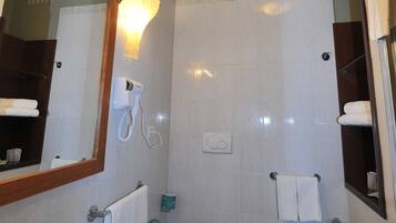 A bathroom with a sink, toilet, bidet, and a mirror.