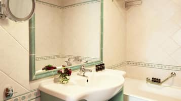 Un baño con un lavabo blanco, un espejo y una bañera.