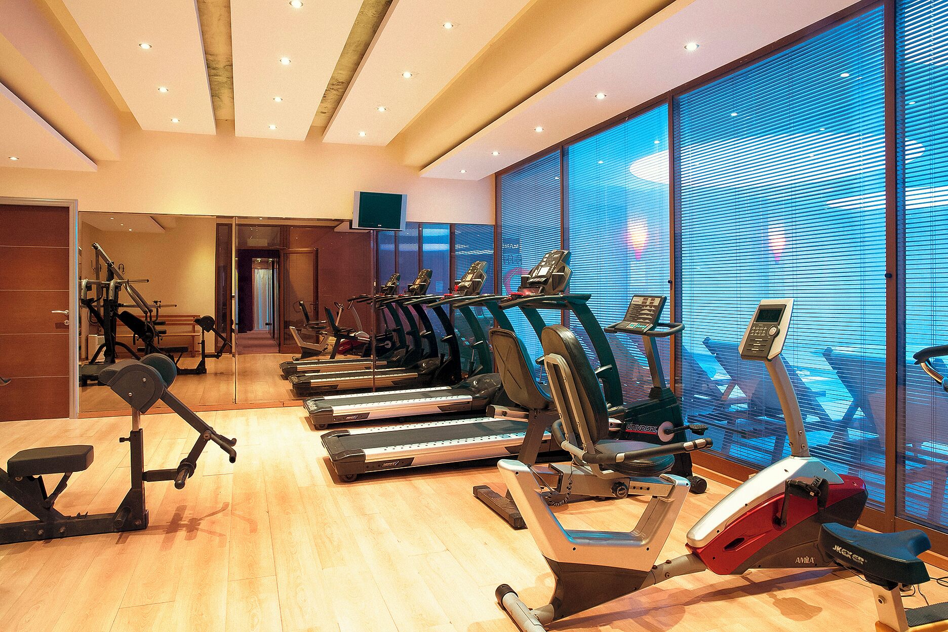 A gym with treadmills, stationary bikes, and a rowing machine.
