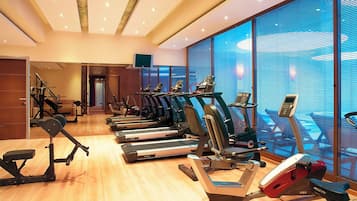A gym with treadmills, stationary bikes, and a rowing machine.