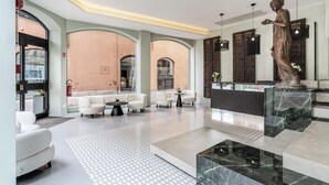 A spacious lobby with a marble floor, a reception desk, and a statue. - Plinius Lifestyle Hotel Lake Como (Como)