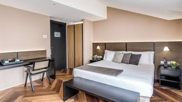 Una habitación de hotel moderna con una cama grande, un escritorio y un banco.