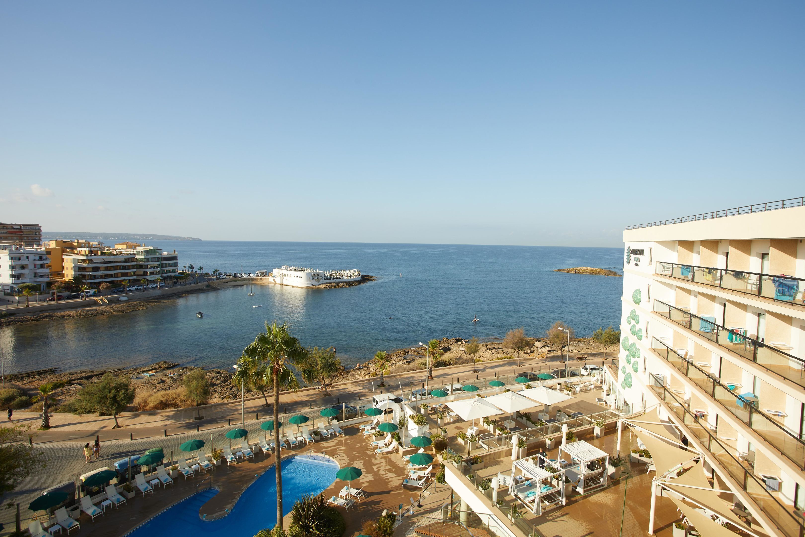 A hotel with a pool, beach view, and a boat dock.