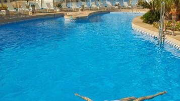 Een buitenzwembad, parasols voor strand/zwembad