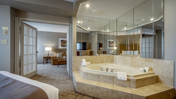 Une chambre d’hôtel dotée d’une grande baignoire, d’une télévision, d’un canapé et d’un coin repas.