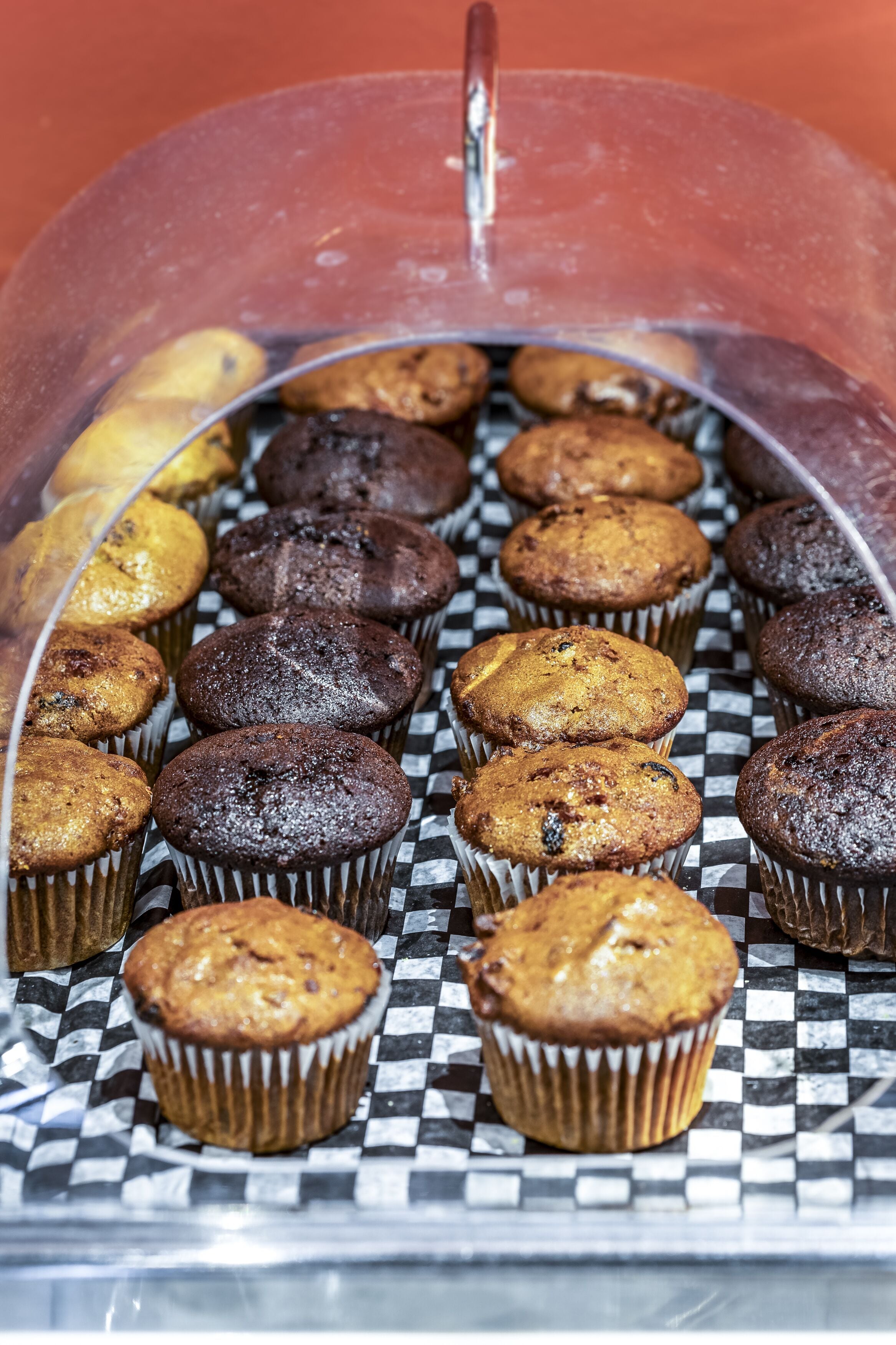Presentació de muffins en vas de paper sobre una safata amb quadres.
