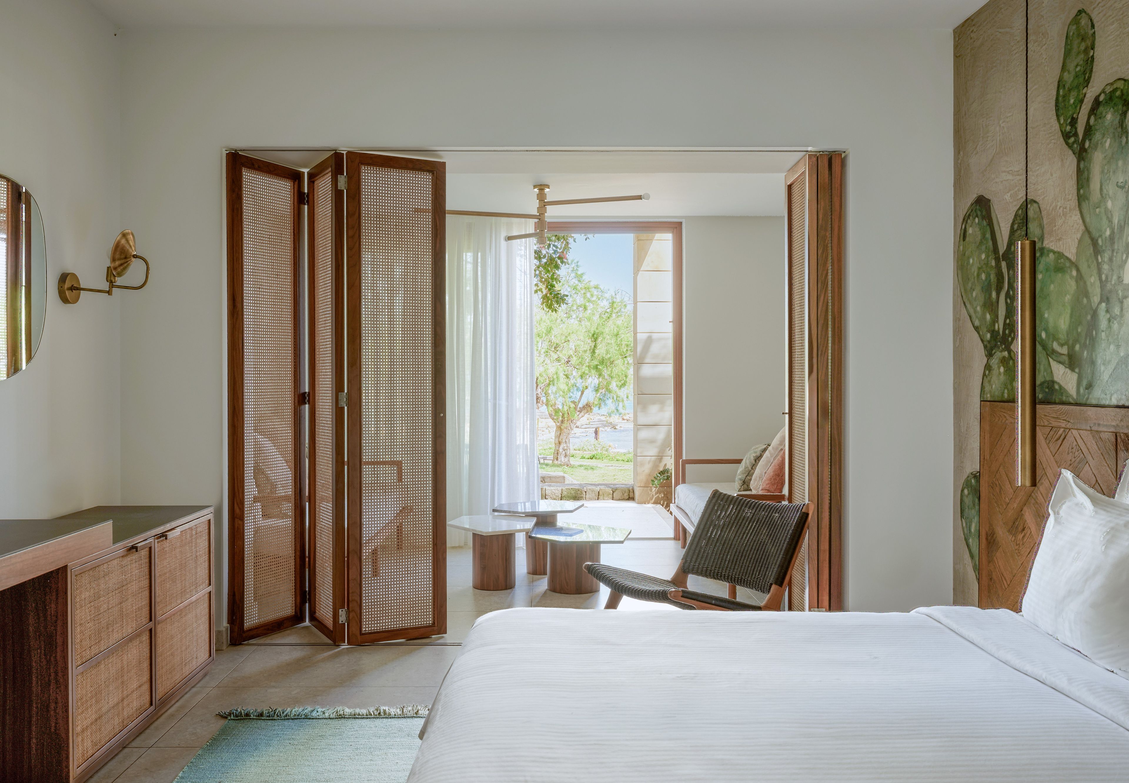 Habitación de hotel con cama, escritorio, silla, mesa y vistas al exterior.