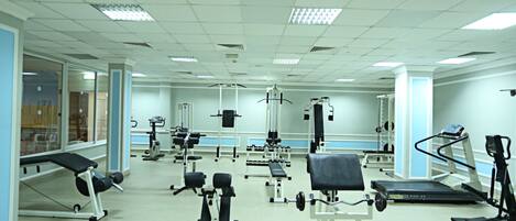 A gym with various exercise equipment, including treadmills, weight machines, and free weights.