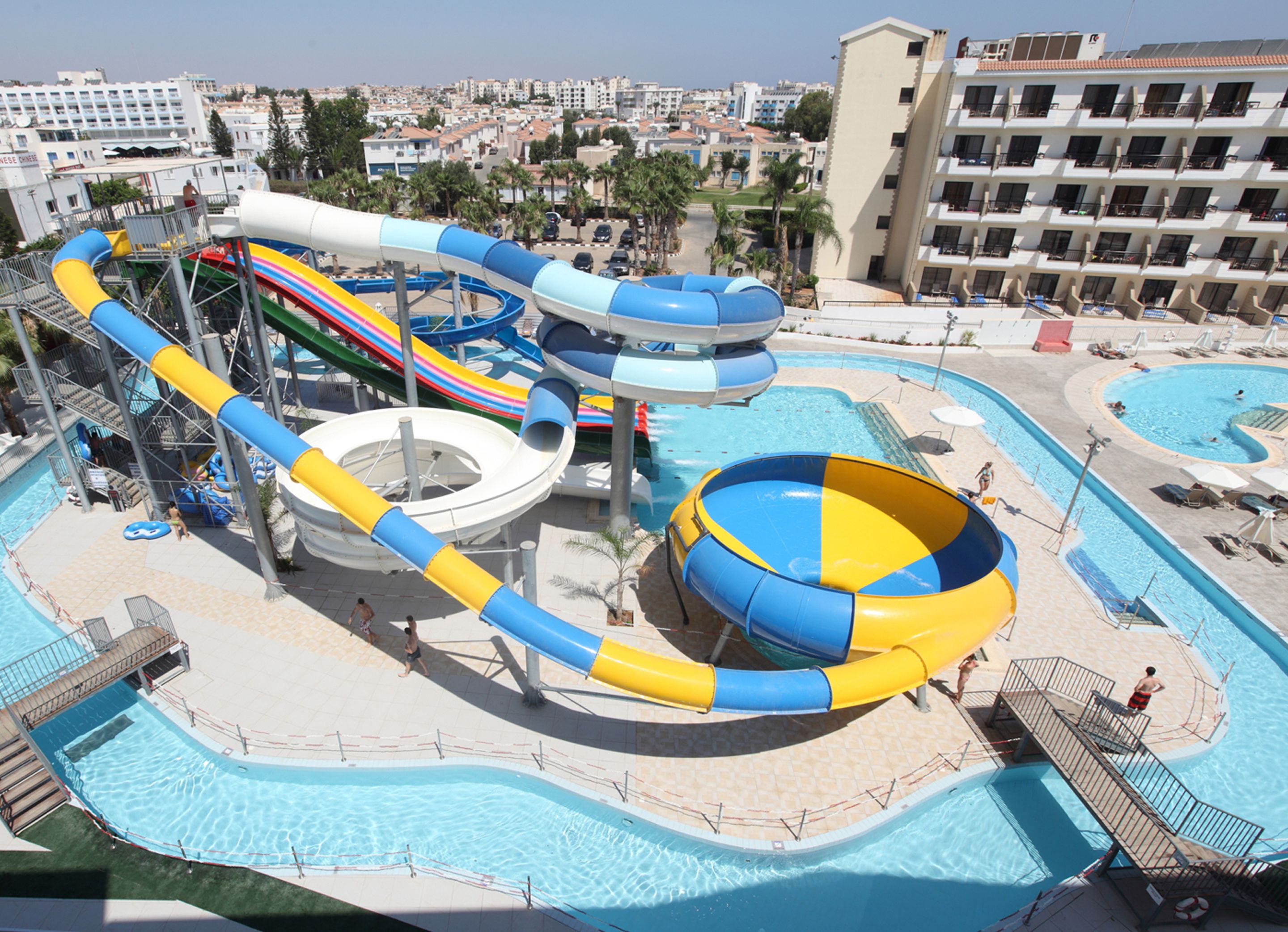 A water park with multiple slides and pools, surrounded by buildings.