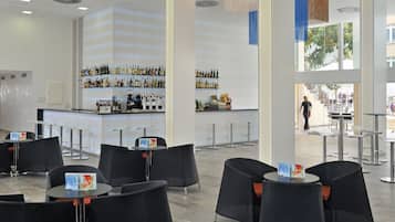 Un área de bar moderna con diversas opciones de asientos y una barra bien surtida.