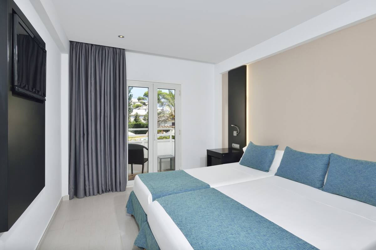 Ein modernes Hotelzimmer mit einem großen Bett, einem Schreibtisch und Blick ins Freie.